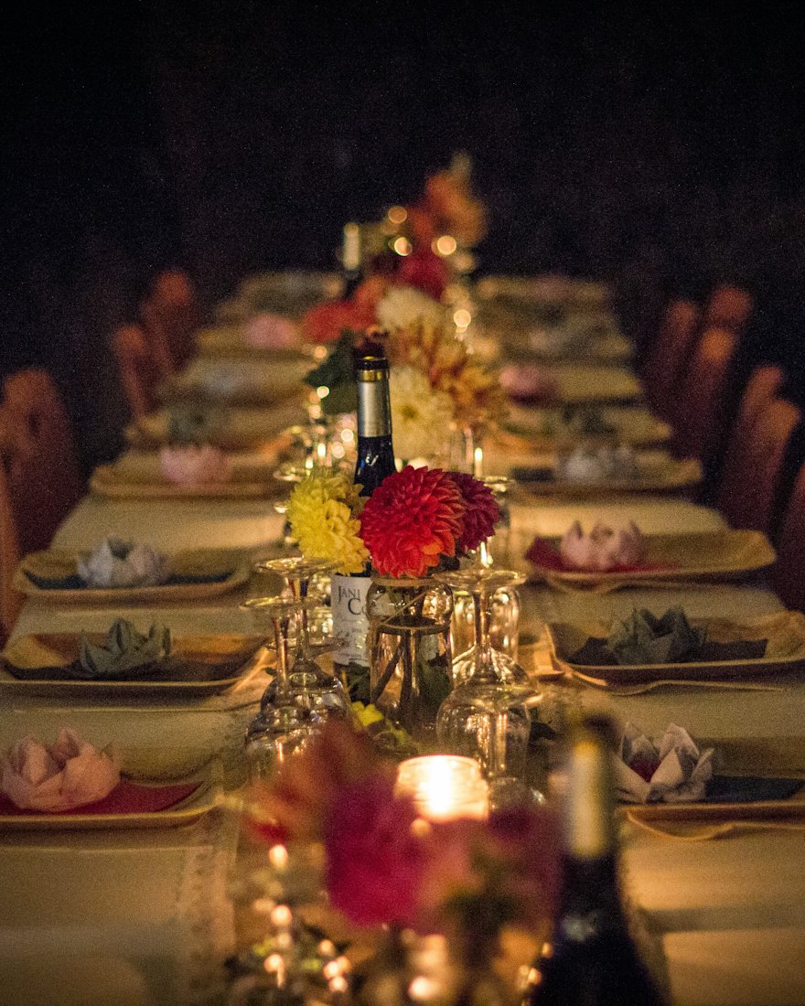 Une longue table dressée aux chandelles pour le dîner