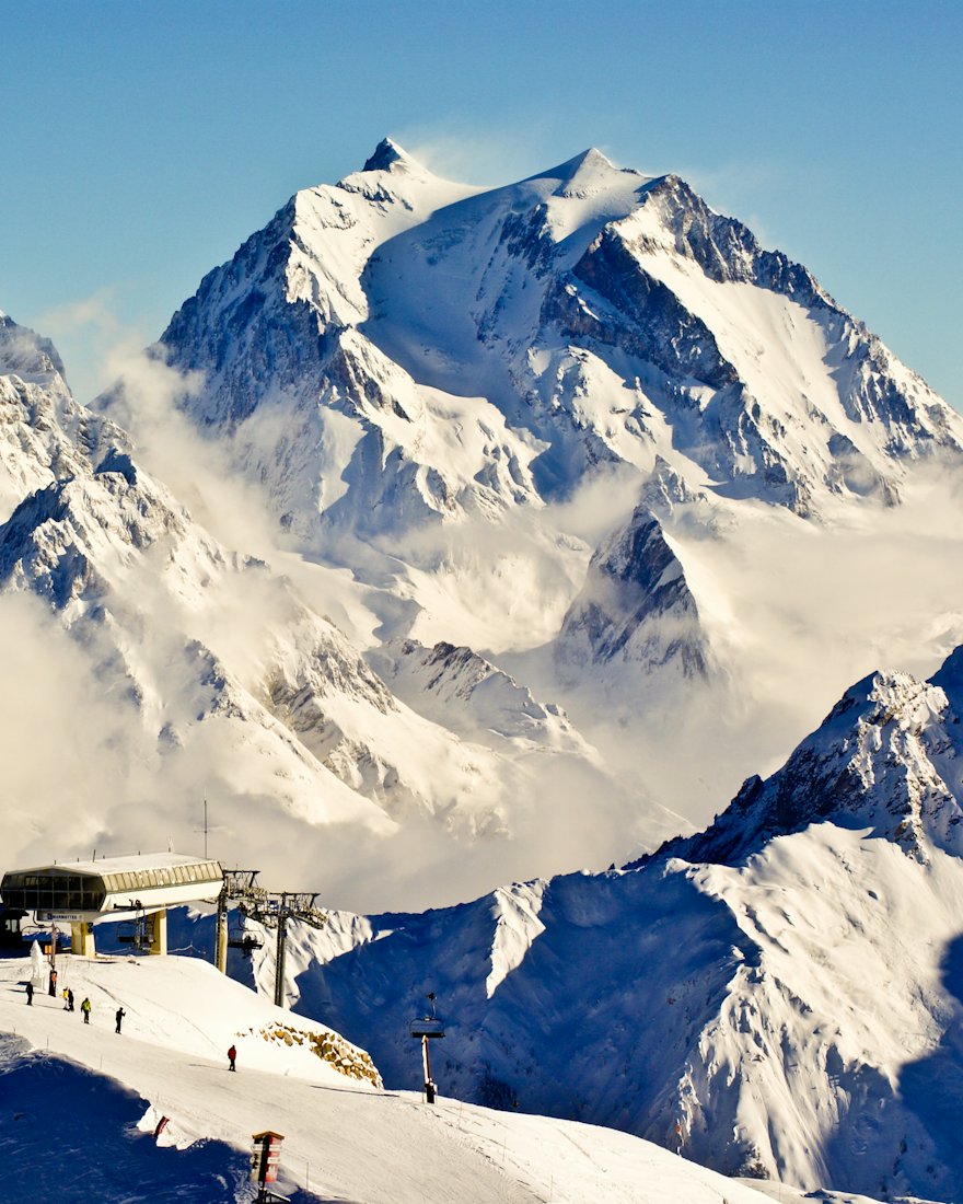 Sommets alpins enneigés au-dessus d’une station de ski